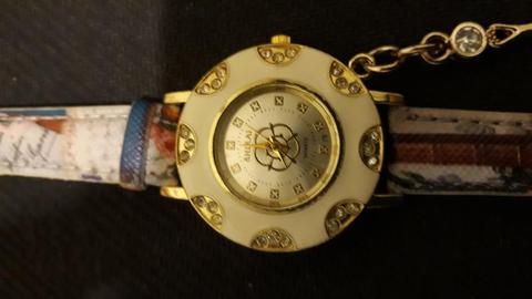 Moderno reloj de mujer, con caja de acero inoxidable y cuadrante esmaltado blanco con detalles de strass